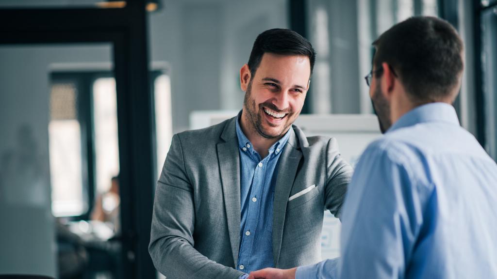 Two men in business attire shaking hands